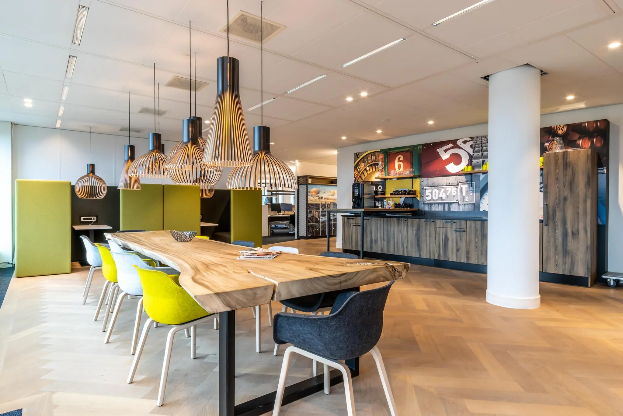 Moderne kantoorruimte aan de Fascinatio Boulevard met houten vergadertafel, designlampen en sfeervolle koffiehoek.